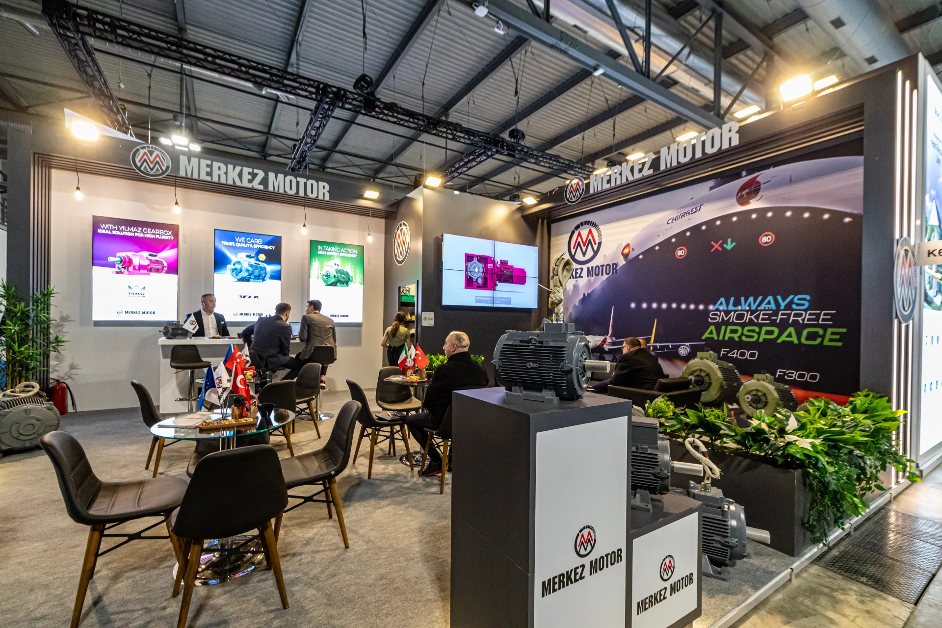 Merkez Motor lounge with motors on plinths and 'Always Smoke-Free Airspace' wall at MCE 2024