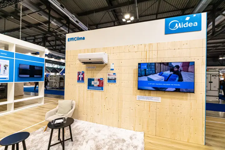 Midea EffiClima wall in natural wood with split unit and seating corner at MCE 2024