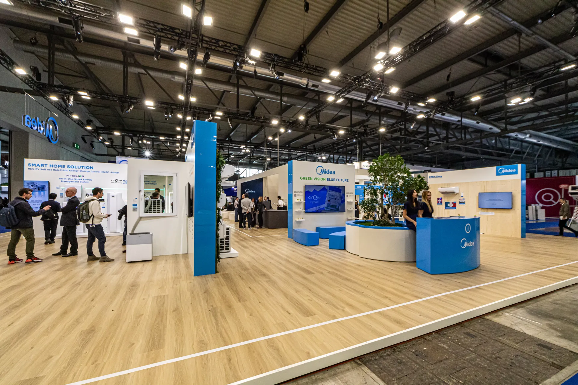 Midea stand overview with tree planter, info desk and product walls at MCE 2024