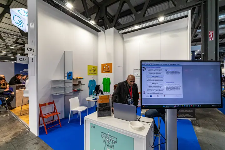 Mr. Dico stand with compliance software shown on a large monitor