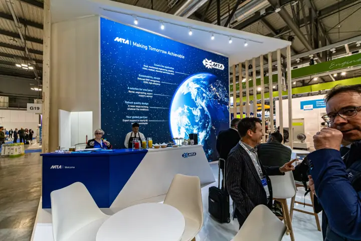 MTA reception counter and drinks bar under a globe graphic at MCE 2024