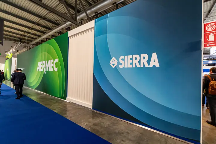 Outer walls of the Sierra and Aermec stands along a blue-carpeted aisle at MCE 2024