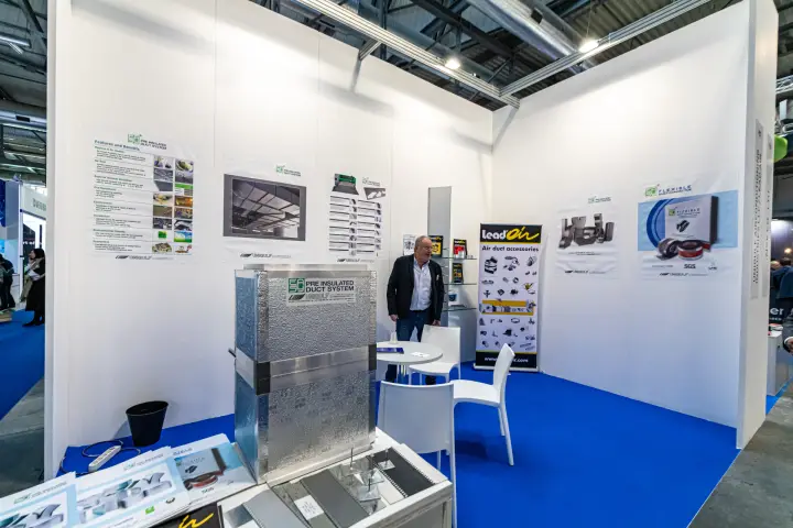 Pre-insulated duct section in front of the Unigulf product posters at MCE 2024