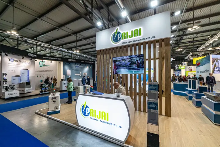 Prijai Heat Exchangers stand with wooden slat tower and backlit reception desk at MCE 2024
