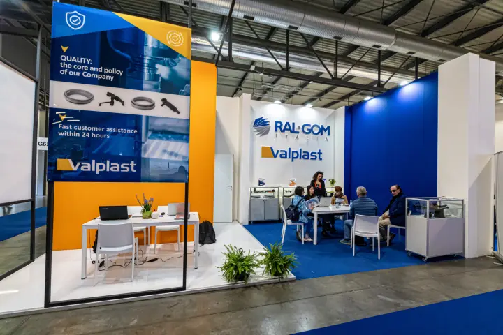 Ral-Gom Italia and Valplast stand with deep blue and orange walls