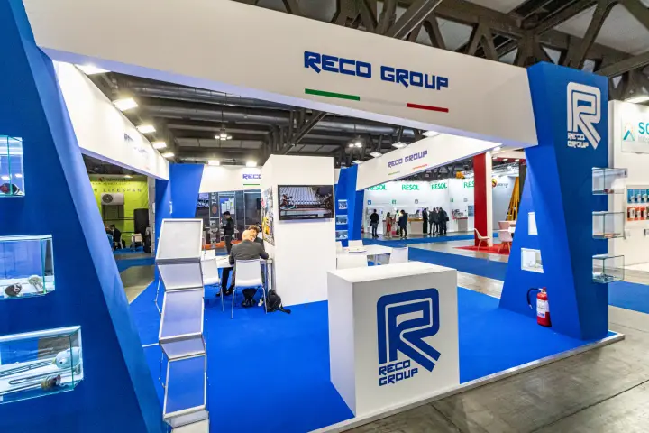 Reco Group R logo counter at the stand entrance on blue carpet