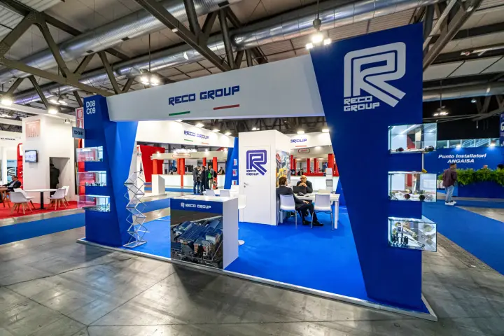 Reco Group stand with blue angled pillars and illuminated product vitrines