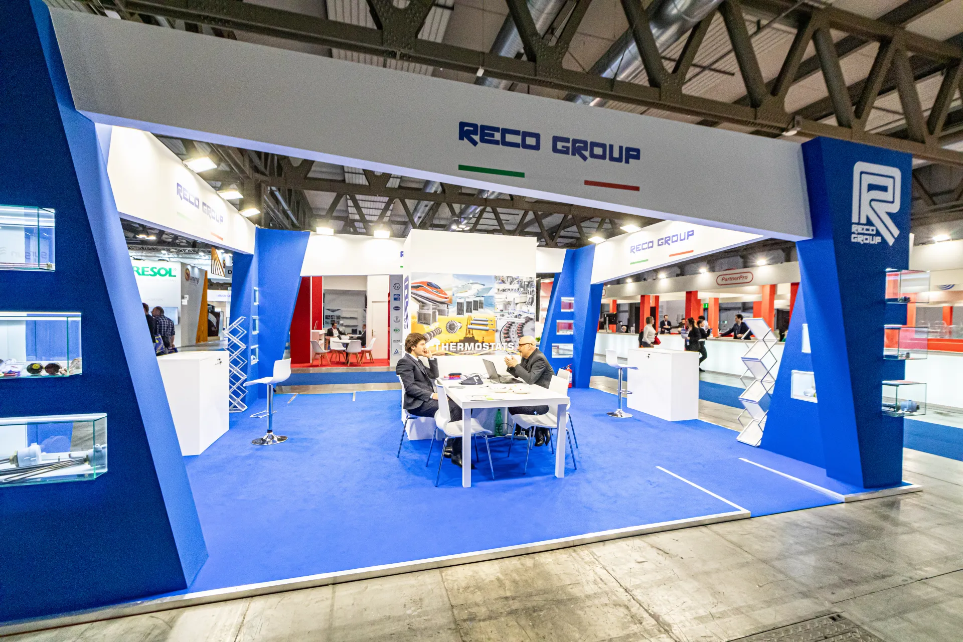 Reco Group stand front with central meeting table and thermostat graphics at MCE 2024