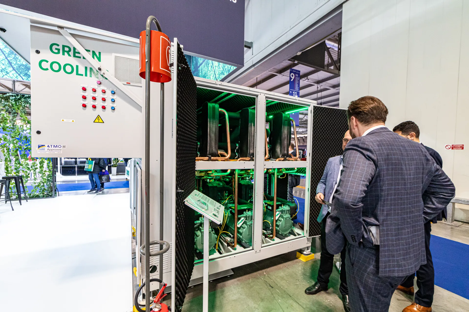 Refrigeration rack with open doors and green-lit compressors at MCE 2024