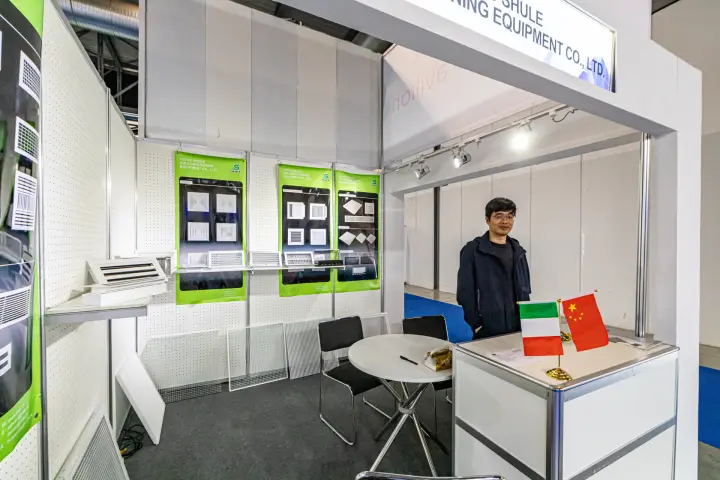 Shule shell-scheme booth with grille samples and green posters at MCE 2024