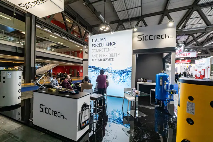 Sicctech stand with storage tanks and 'Italian Excellence' backlit panel at MCE 2024