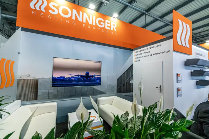 Sonniger lounge with white sofas and video screen
