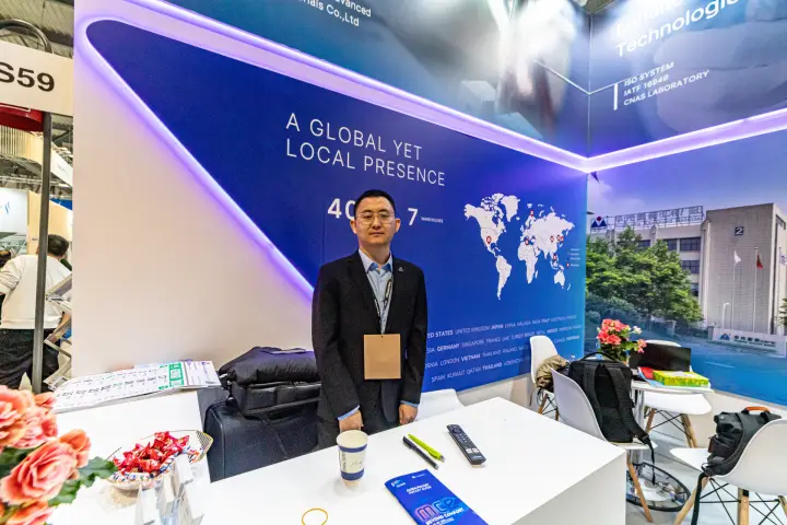 Staff member at the S59 reception desk with a world map wall