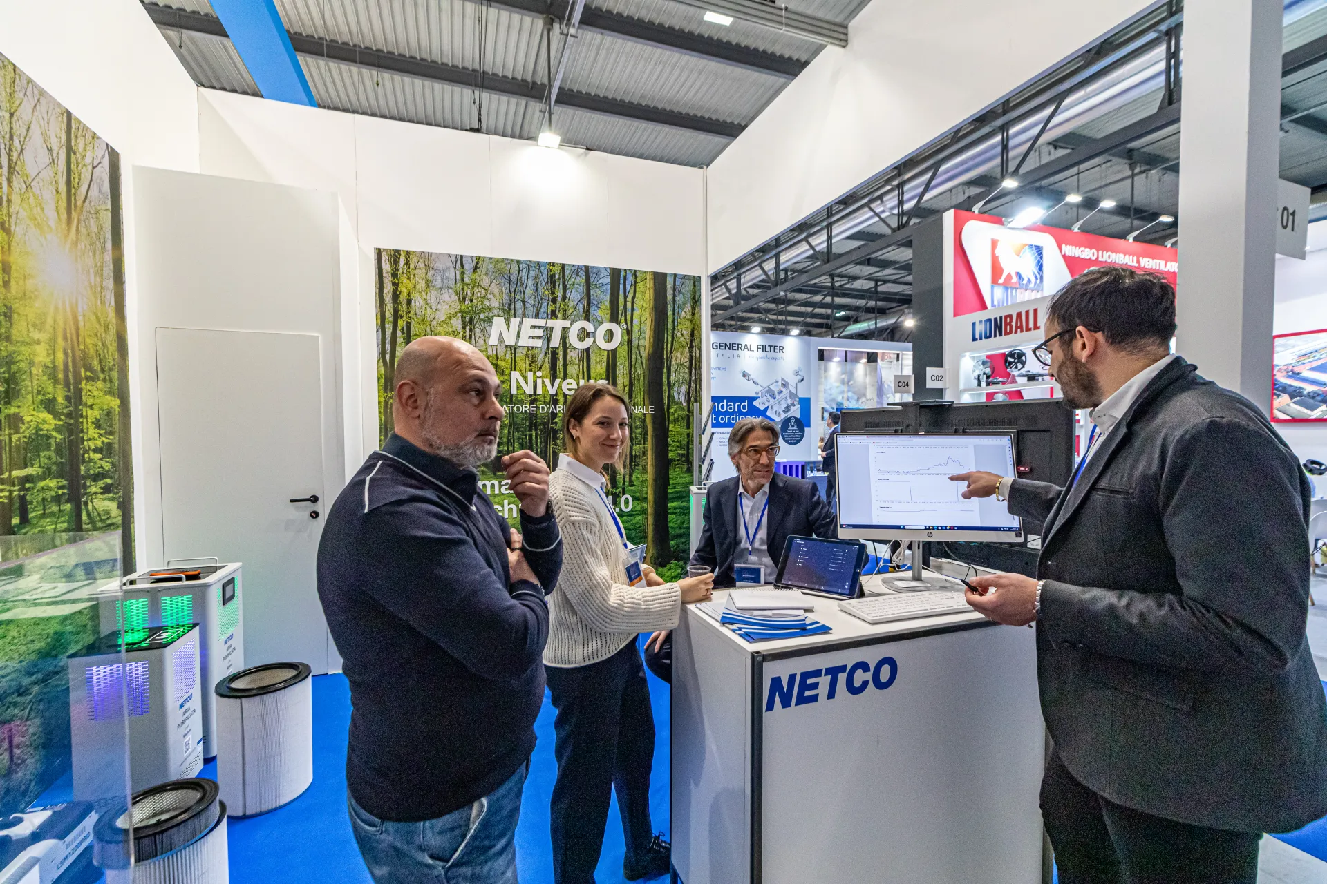 Staff at the Netco counter presenting a data chart on a monitor at MCE 2024