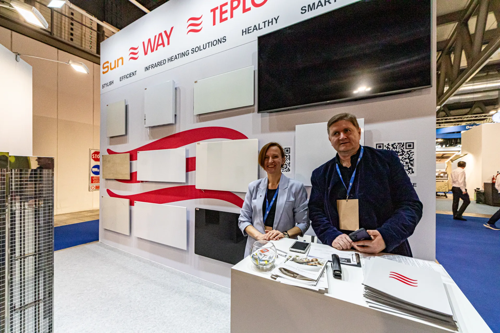Staff at the SunWay and TeploCeramic counter in front of infrared panels at MCE 2024