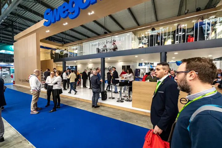 Swegon double-deck stand with wood cladding and bar area at MCE 2024