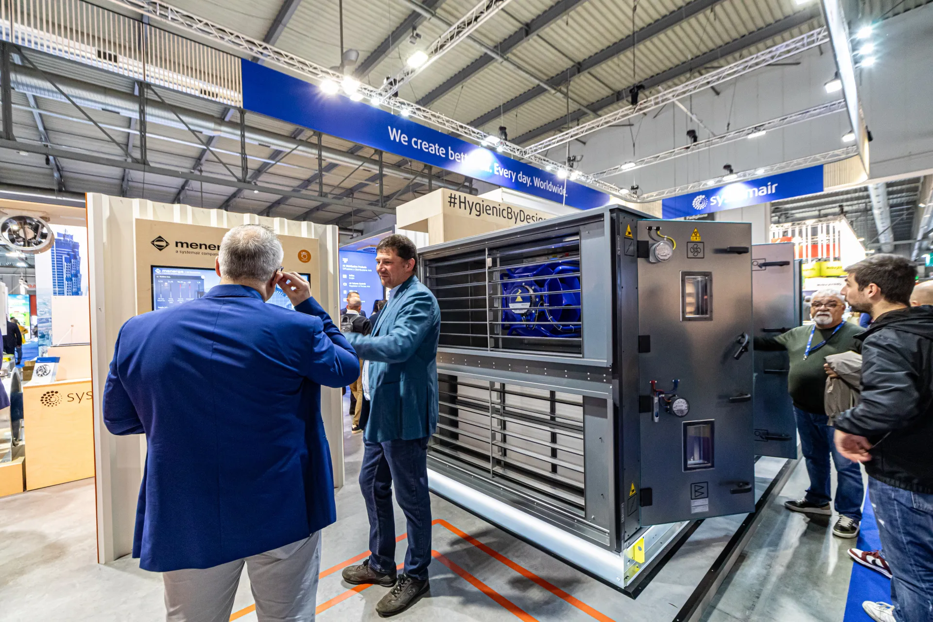 Systemair unit with exposed blue fan beside a Menerga display totem at MCE 2024