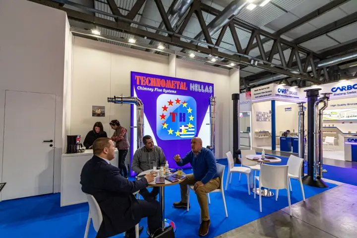 Technometal Hellas meeting area in front of a backlit chimney flue systems wall at MCE 2024