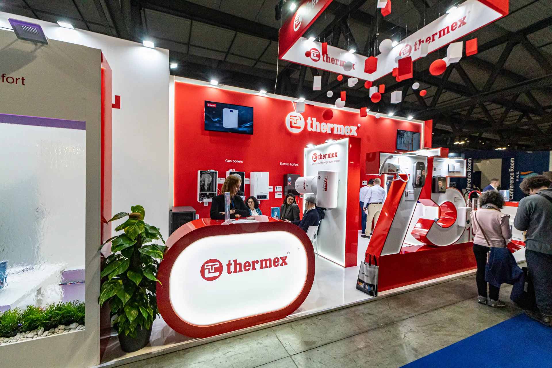 Thermex reception counter with gas and electric boilers on the red wall at MCE 2024