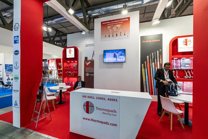 Thermopads stand with heating cables on red arched shelving at MCE 2024
