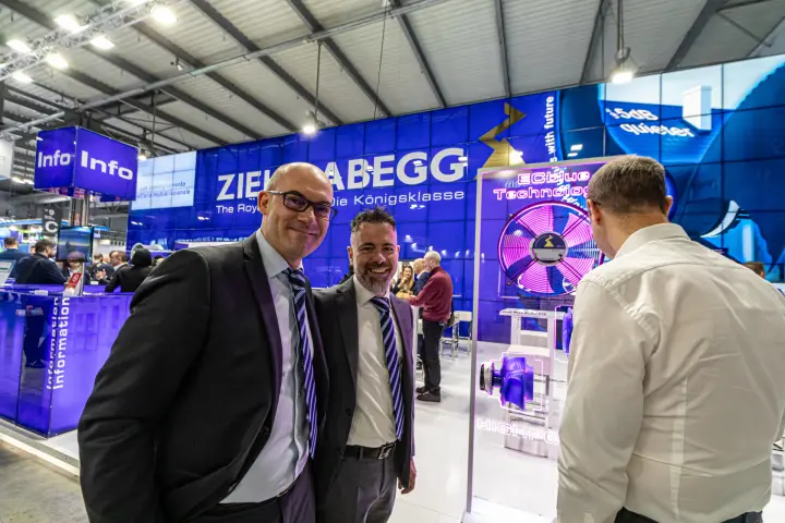 Two people posing in front of the Ziehl-Abegg ECblue display