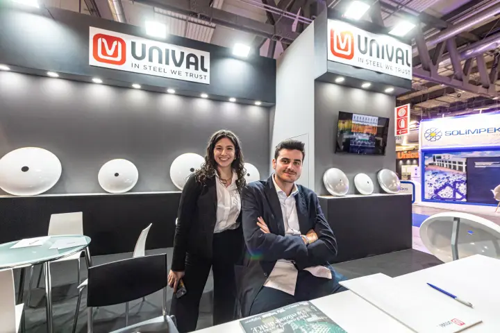 Unival staff in front of white steel dished ends on a grey wall