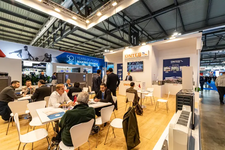 Üntes stand with busy meeting tables under the Hall 11 sign at MCE 2024
