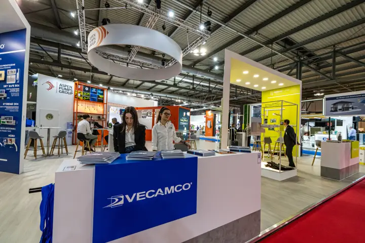 Vecamco counter with the Aspen Pumps Group lounge and 2Emmeclima booth behind at MCE 2024