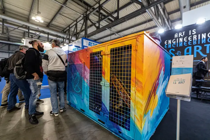 Visitors around Imbat's brush-painted unit with mesh doors at MCE 2024