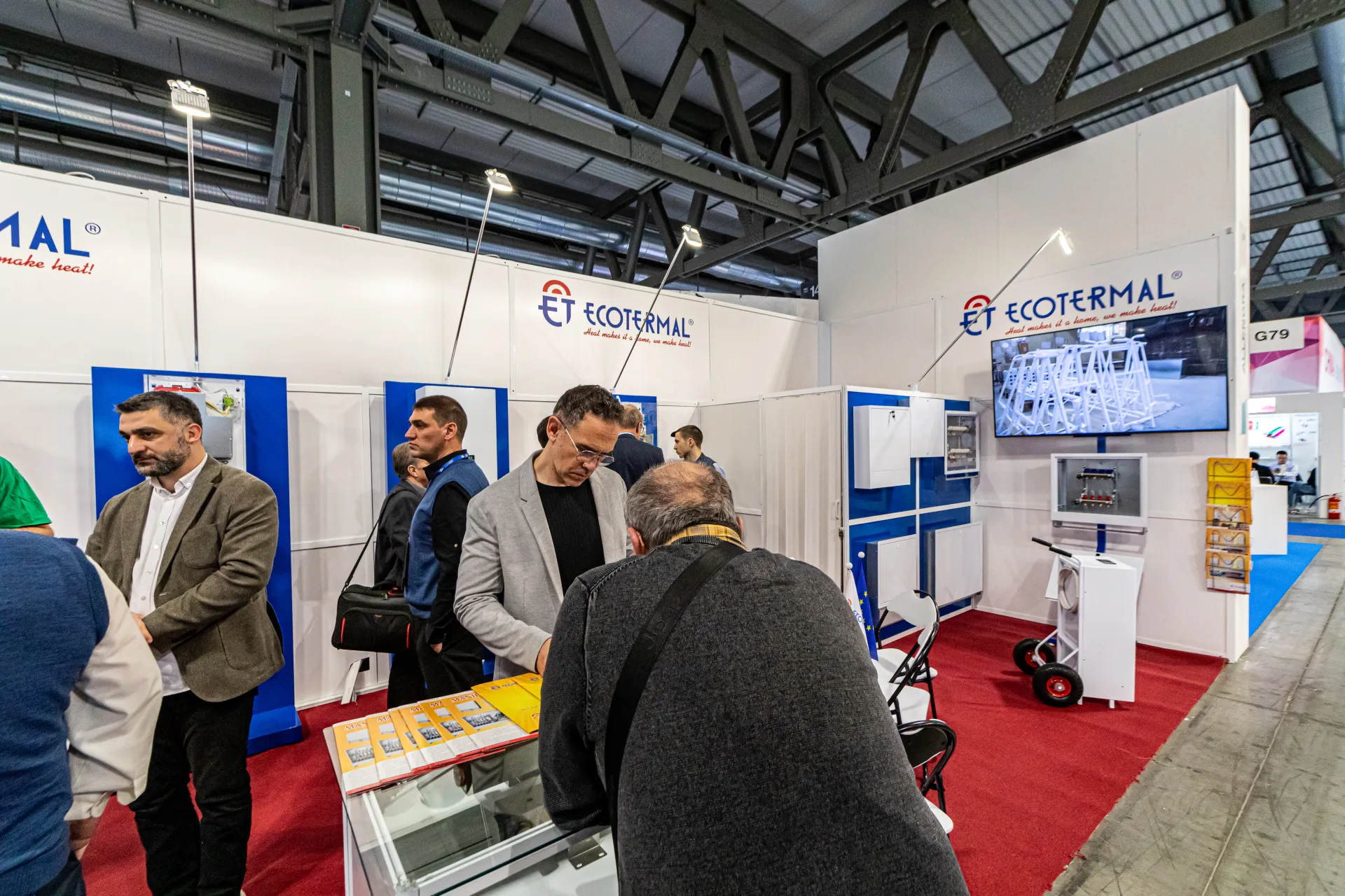 Visitors browse manifold box brochures at the Ecotermal stand at MCE 2024