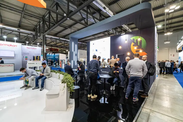 Visitors in the dark gloss meeting zone of the Enerblue stand