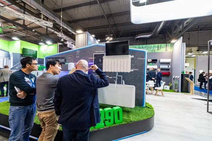Visitors examining an R290 heating system display with radiator at MCE 2024