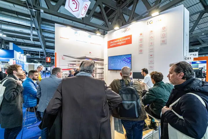 Visitors gather for a MagiCAD software demo on the stand screen at MCE 2024