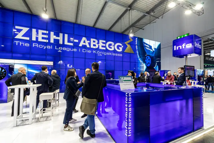 Visitors gathering at the Ziehl-Abegg information desk and high tables