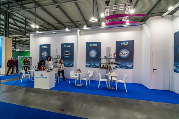 Wide view of the Makro Teknik stand with four product-range posters