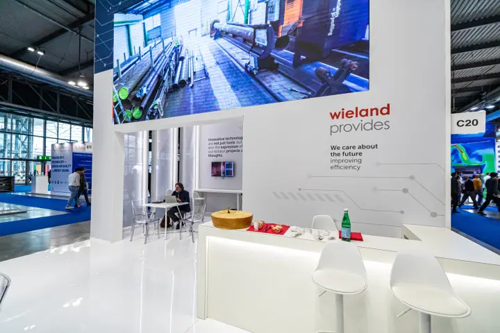 Wieland bar counter beneath an LED wall showing tube production