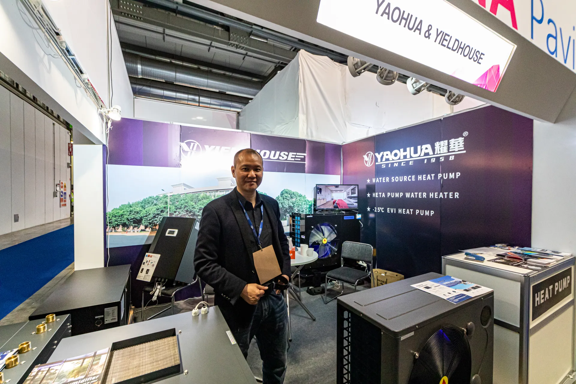 Yaohua & Yieldhouse booth with heat pump water heaters on purple walls at MCE 2024