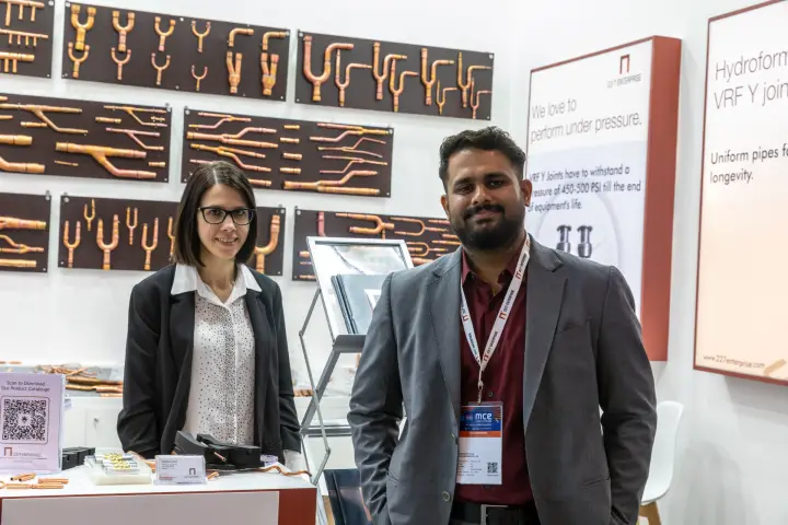 22/7 Enterprise staff beside VRF Y-joint lightboxes at MCE 2026