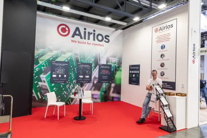 Airios stand with "We build for comfort" circuit-board backdrop