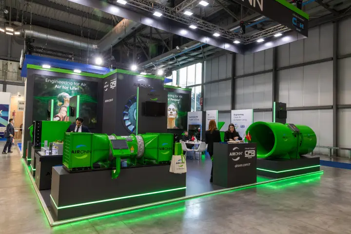 Aironn stand with green axial duct fans on green-lit plinths at MCE 2026