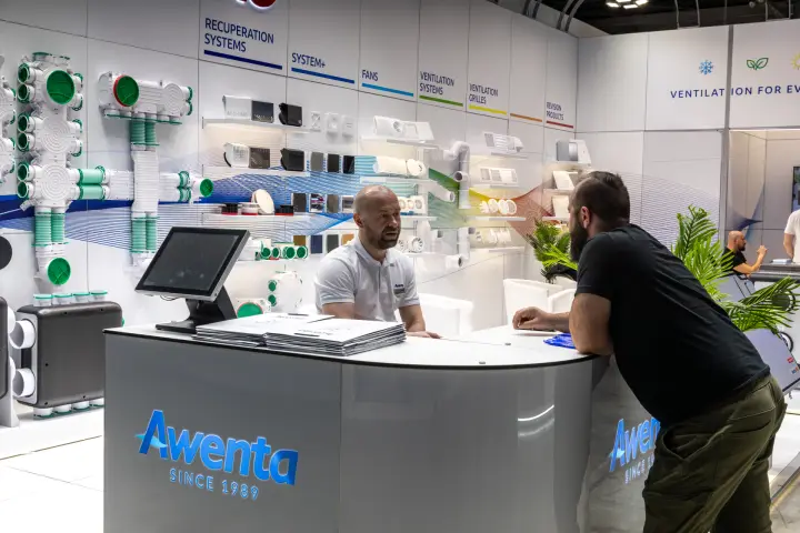 Awenta reception counter with blue SINCE 1989 logo and product wall