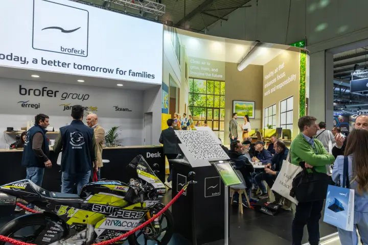 Brofer group desk with Erregi and Steam logos and a racing motorcycle at MCE 2026