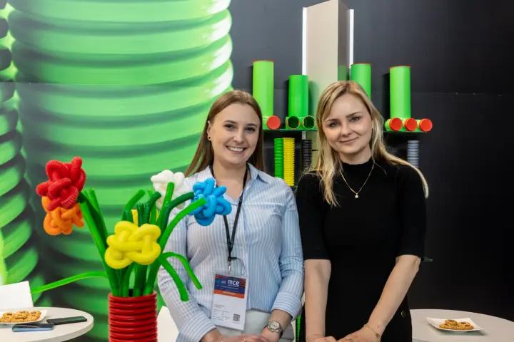 Close portrait of TT Plast staff beside green pipe samples