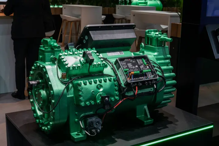 Close-up of a green reciprocating compressor with VARISTEP tag