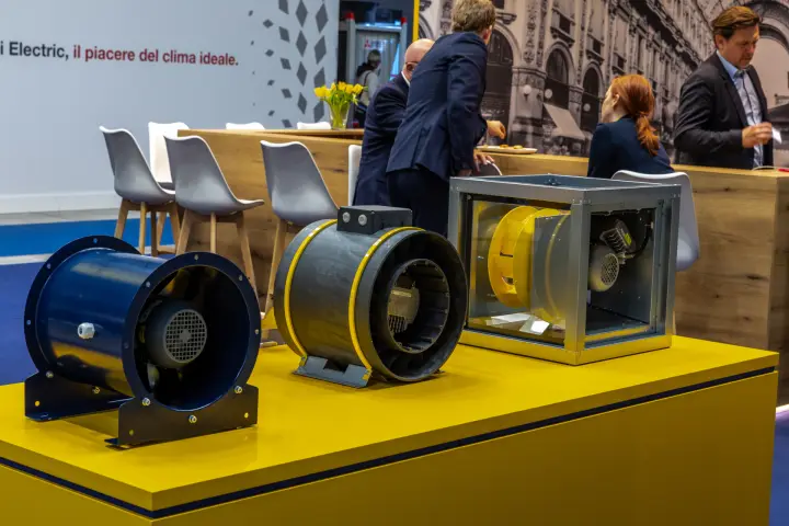 Close-up of inline fans and a cased centrifugal fan on a yellow plinth at MCE 2026