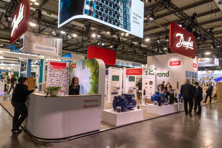 Danfoss "Welcome Benvenuti" desk with compressors and suspended screen at MCE 2026