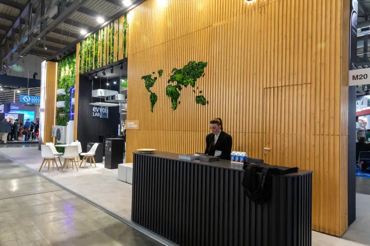 Evvoli reception desk before a timber wall with a greenery world map
