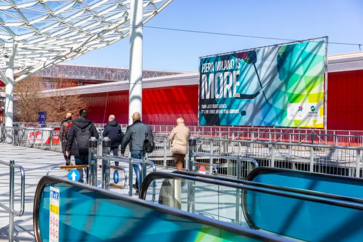 'Fiera Milano is More' Winter Games banner beside the moving walkways at MCE 2026