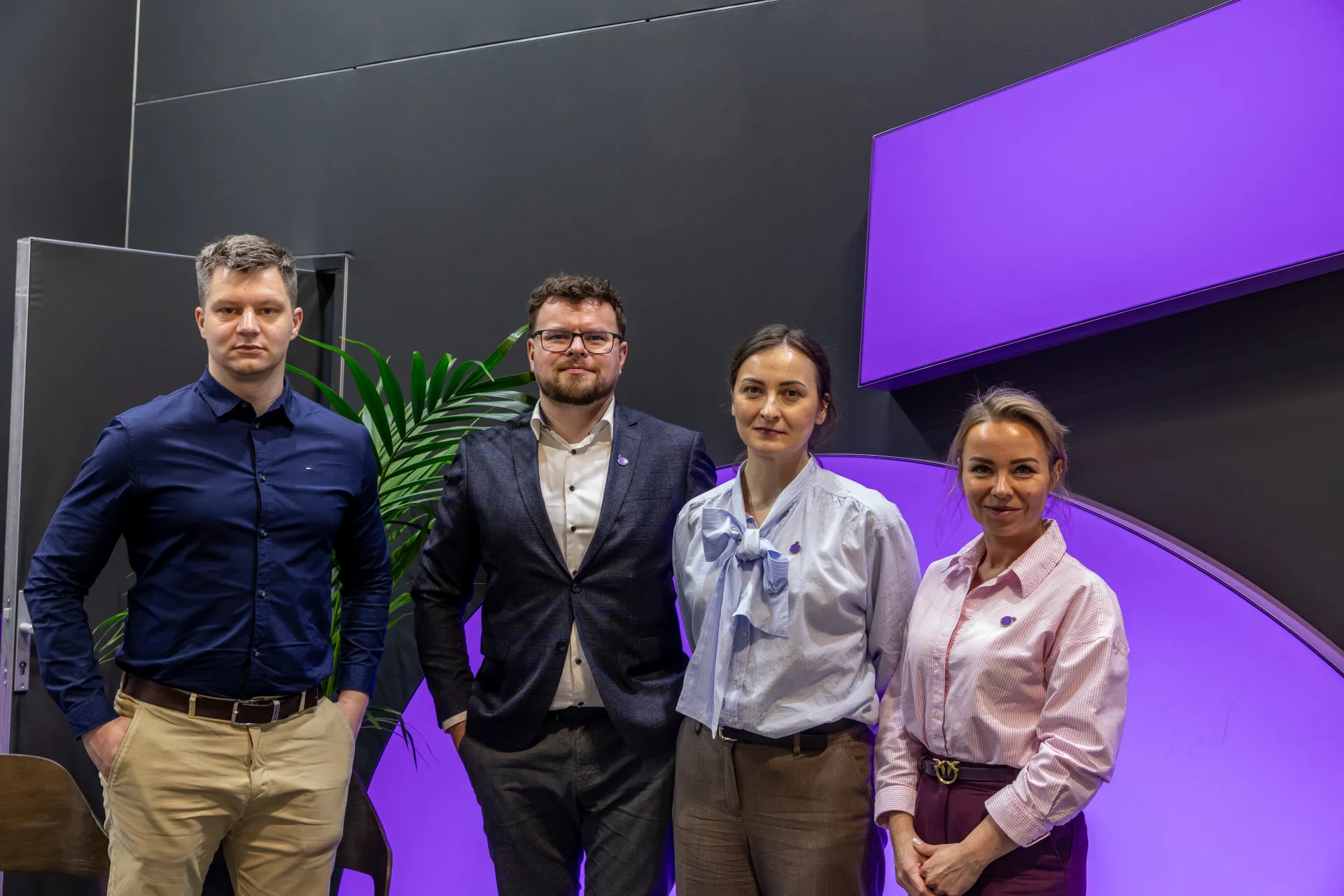 Four staff members in front of a purple arch and dark wall at MCE 2026