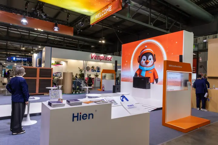 Hien reception desk with brochures and penguin mascot backdrop at MCE 2026